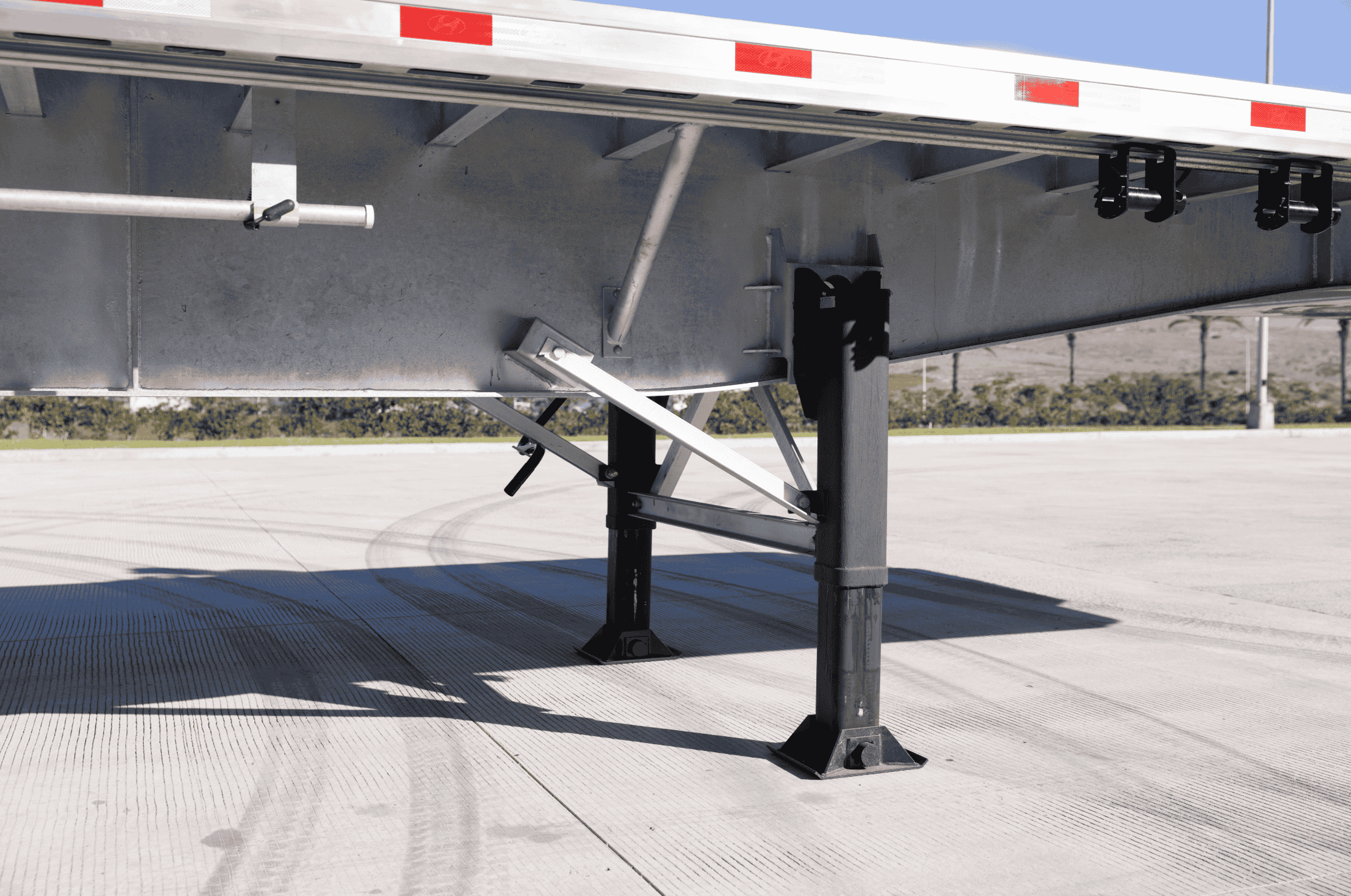 Underside view of a Hyundai Translead Latitude Flatbed trailer, showcasing its robust landing gear and structural components, demonstrating Hyundai Translead's advanced trailer technology.